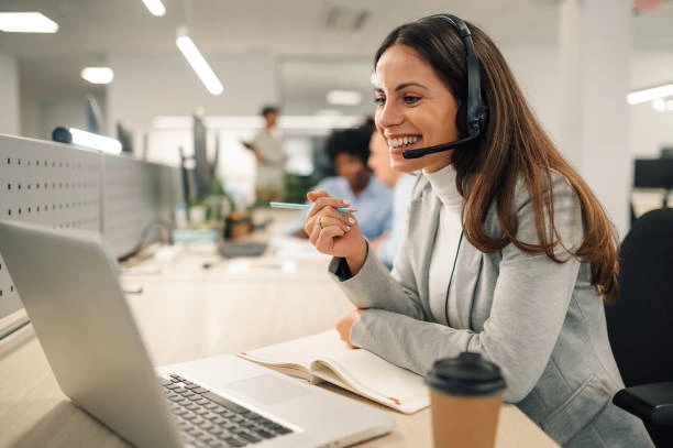 Finance broker smiling while working a Pay Per Deal lead at her desk